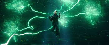 Movie still from “Sonic the Hedgehog 2” (2022), directed by Jeff Fowler – A man is jumping in the air in front of green lights; Wide shot, Low angle