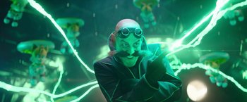 Movie still from “Sonic the Hedgehog 2” (2022), directed by Jeff Fowler – A man with a beard and a mustache wearing goggles and a black jacket; Medium shot, Over the shoulder angle