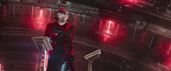 Movie still from “Sonic the Hedgehog 2” (2022), directed by Jeff Fowler – A man in a red and black outfit smoking a cigarette; Medium shot, Low angle