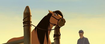 Movie still from “Spirit: Stallion of the Cimarron” (2002), directed by Lorna Cook – A horse with long hair is standing next to a pole; Close Up shot, Over the shoulder angle
