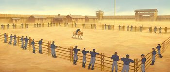 Movie still from “Spirit: Stallion of the Cimarron” (2002), directed by Lorna Cook – A man riding a horse in a fenced in area; Extreme Wide shot, High angle