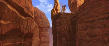 Movie still from “Spirit: Stallion of the Cimarron” (2002), directed by Lorna Cook – A person on a horse standing on top of a cliff; Extreme Wide shot, Low angle