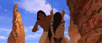 Movie still from “Spirit: Stallion of the Cimarron” (2002), directed by Lorna Cook – A man riding on the back of a brown horse; Medium shot, Over the shoulder angle