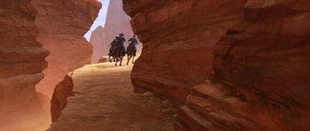 Movie still from “Spirit: Stallion of the Cimarron” (2002), directed by Lorna Cook – Two men on horseback riding through a canyon; Extreme Wide shot, Low angle