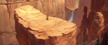 Movie still from “Spirit: Stallion of the Cimarron” (2002), directed by Lorna Cook – A person standing on top of a rock cliff; Extreme Wide shot, Overhead angle