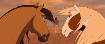 Movie still from “Spirit: Stallion of the Cimarron” (2002), directed by Lorna Cook – Two horses face each other in front of a man in a field; Close Up shot, Over the shoulder angle