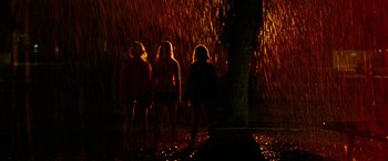 Movie still from “Spring Breakers” (2012), directed by Harmony Korine – A group of people standing next to a tree in the dark; Wide shot, Low angle
