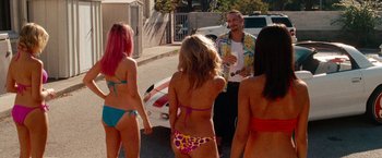 Movie still from “Spring Breakers” (2012), directed by Harmony Korine – A group of people standing next to each other on a street; Wide shot, Over the shoulder angle