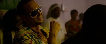 Movie still from “Spring Breakers” (2012), directed by Harmony Korine – A man wearing sunglasses while holding a cigarette in his mouth; Close Up shot, Over the shoulder angle