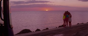 Movie still from “Spring Breakers” (2012), directed by Harmony Korine – The sun is setting over the ocean on a cloudy day; Extreme Wide shot, Over the shoulder angle