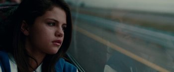 Movie still from “Spring Breakers” (2012), directed by Harmony Korine – A young woman sitting in a car looking out the window; Close Up shot, Over the shoulder angle