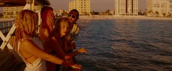 Movie still from “Spring Breakers” (2012), directed by Harmony Korine – A group of people standing next to a body of water; Medium shot, High angle