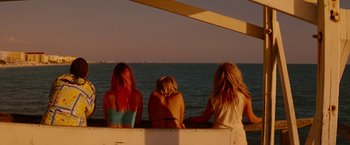 Movie still from “Spring Breakers” (2012), directed by Harmony Korine – A group of women sitting on top of a boat in the water; Wide shot, Over the shoulder angle