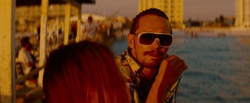 Movie still from “Spring Breakers” (2012), directed by Harmony Korine – A man wearing sunglasses sitting next to a woman; Close Up shot, Over the shoulder angle