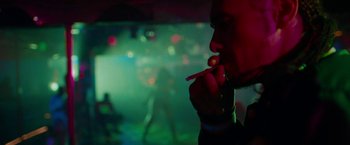 Movie still from “Spring Breakers” (2012), directed by Harmony Korine – A man smoking a cigarette in front of an audience; Close Up shot, Over the shoulder angle