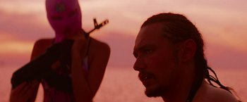 Movie still from “Spring Breakers” (2012), directed by Harmony Korine – A man and a woman are looking at each other in the sunset; Close Up shot, Over the shoulder angle
