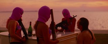 Movie still from “Spring Breakers” (2012), directed by Harmony Korine – Two women in pink balaclavas are holding guns; Medium shot, Low angle