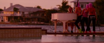 Movie still from “Spring Breakers” (2012), directed by Harmony Korine – A woman sitting at a piano on a pier; Wide shot, High angle