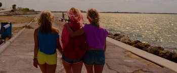 Movie still from “Spring Breakers” (2012), directed by Harmony Korine – A group of women standing next to a body of water; Wide shot, Low angle