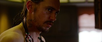 Movie still from “Spring Breakers” (2012), directed by Harmony Korine – A person with tattoos on their face; Close Up shot, Over the shoulder angle