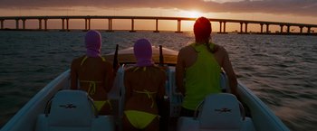 Movie still from “Spring Breakers” (2012), directed by Harmony Korine – A group of people sitting on a boat in the water; Medium shot, Low angle