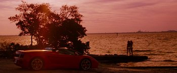 Movie still from “Spring Breakers” (2012), directed by Harmony Korine – A red sports car parked on the side of the road near the water; Extreme Wide shot, High angle