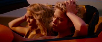 Movie still from “Spring Breakers” (2012), directed by Harmony Korine – Two women in a car with one of the two women in the back of the car looking in the mirror; Close Up shot, Over the shoulder angle