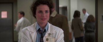 Movie still from “St. Elmo's Fire” (1985), directed by Joel Schumacher – A woman in a white lab coat and tie; Close Up shot, Over the shoulder angle