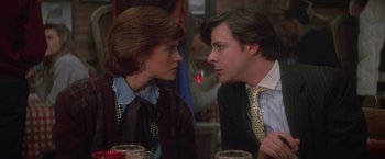 Movie still from “St. Elmo's Fire” (1985), directed by Joel Schumacher – A man and a woman sitting at a dinner table; Close Up shot, Over the shoulder angle