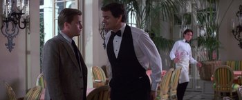 Movie still from “St. Elmo's Fire” (1985), directed by Joel Schumacher – A man in a tuxedo standing next to another man in a suit; Medium shot, Over the shoulder angle