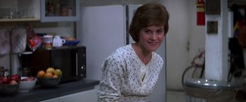 Movie still from “St. Elmo's Fire” (1985), directed by Joel Schumacher – A woman standing in front of an open refrigerator; Close Up shot, Over the shoulder angle