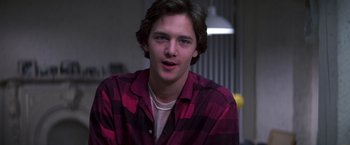 Movie still from “St. Elmo's Fire” (1985), directed by Joel Schumacher – A young man in a red and black plaid shirt; Close Up shot, Over the shoulder angle