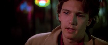 Movie still from “St. Elmo's Fire” (1985), directed by Joel Schumacher – A young man's face in the dark; Close Up shot, Over the shoulder angle