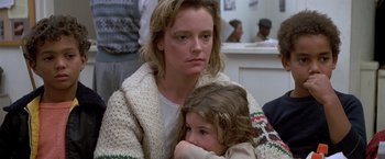Movie still from “St. Elmo's Fire” (1985), directed by Joel Schumacher – A woman and a child are sitting together; Close Up shot, Over the shoulder angle