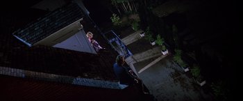 Movie still from “St. Elmo's Fire” (1985), directed by Joel Schumacher – A man and a woman standing on the steps at night; Wide shot, High angle