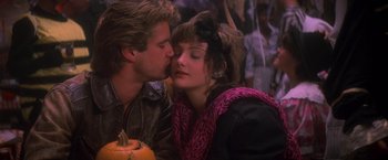 Movie still from “St. Elmo's Fire” (1985), directed by Joel Schumacher – A man and a woman kissing in front of a crowd of onlookers; Close Up shot, Low angle
