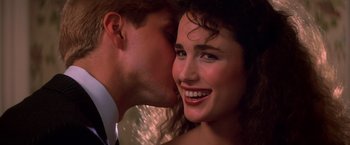 Movie still from “St. Elmo's Fire” (1985), directed by Joel Schumacher – A man kissing a woman on the cheek; Close Up shot, Over the shoulder angle