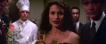 Movie still from “St. Elmo's Fire” (1985), directed by Joel Schumacher – A woman holding a glass of wine in her hand; Close Up shot, Over the shoulder angle