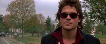 Movie still from “St. Elmo's Fire” (1985), directed by Joel Schumacher – A person wearing sunglasses; Close Up shot, Over the shoulder angle