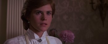 Movie still from “St. Elmo's Fire” (1985), directed by Joel Schumacher – A young woman wearing a white shirt and pearl necklace; Close Up shot, Over the shoulder angle