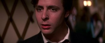 Movie still from “St. Elmo's Fire” (1985), directed by Joel Schumacher – A person wearing a suit and tie; Close Up shot, High angle