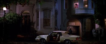 Movie still from “St. Elmo's Fire” (1985), directed by Joel Schumacher – A car parked on the side of the road at night; Wide shot, High angle