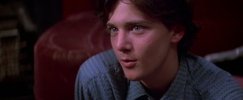 Movie still from “St. Elmo's Fire” (1985), directed by Joel Schumacher – A person wearing a blue shirt; Close Up shot, Low angle