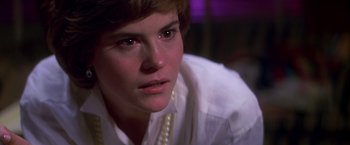 Movie still from “St. Elmo's Fire” (1985), directed by Joel Schumacher – A person wearing a white shirt; Close Up shot, Over the shoulder angle