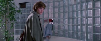 Movie still from “St. Elmo's Fire” (1985), directed by Joel Schumacher – A woman standing in front of a glass block wall; Medium shot, Low angle