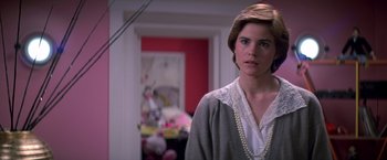 Movie still from “St. Elmo's Fire” (1985), directed by Joel Schumacher – A woman in a white shirt and a gray sweater; Close Up shot, Over the shoulder angle