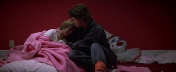 Movie still from “St. Elmo's Fire” (1985), directed by Joel Schumacher – A man and a woman sitting on a bed; Wide shot, High angle