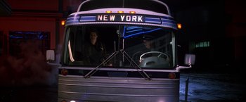 Movie still from “St. Elmo's Fire” (1985), directed by Joel Schumacher – Two people are sitting on a bus at night; Wide shot, Low angle