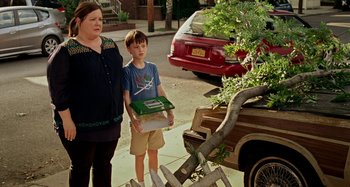 Movie still from “St. Vincent” (2014), directed by Theodore Melfi – A woman and a boy standing on the sidewalk; Medium shot, Over the shoulder angle