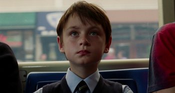 Movie still from “St. Vincent” (2014), directed by Theodore Melfi – A boy in a suit and tie on a bus; Close Up shot, Low angle